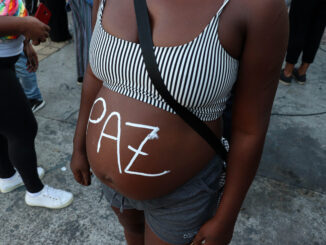 Manifestante grávida pinta 'Paz' em sua barriga durante protesto. Foto por Alexandre Cerqueira