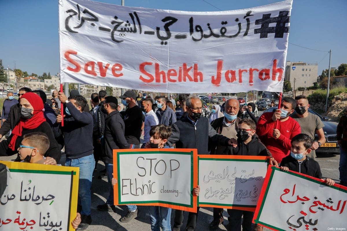 Protesto de Palestinos no bairro de Sheikh Jarrah, em Jerusalém, com faixas onde se lê 'Salvem Sheikh Jarrah' e 'Parem a Limpeza Étnica' em Março de 2021. Foto por: Ahmad Gharabli/AFP