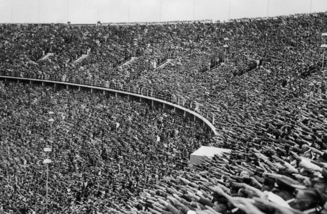Espectadores nas olimpíadas de 1936 dão saudação nazista com entrada de Hitler no estádio. 