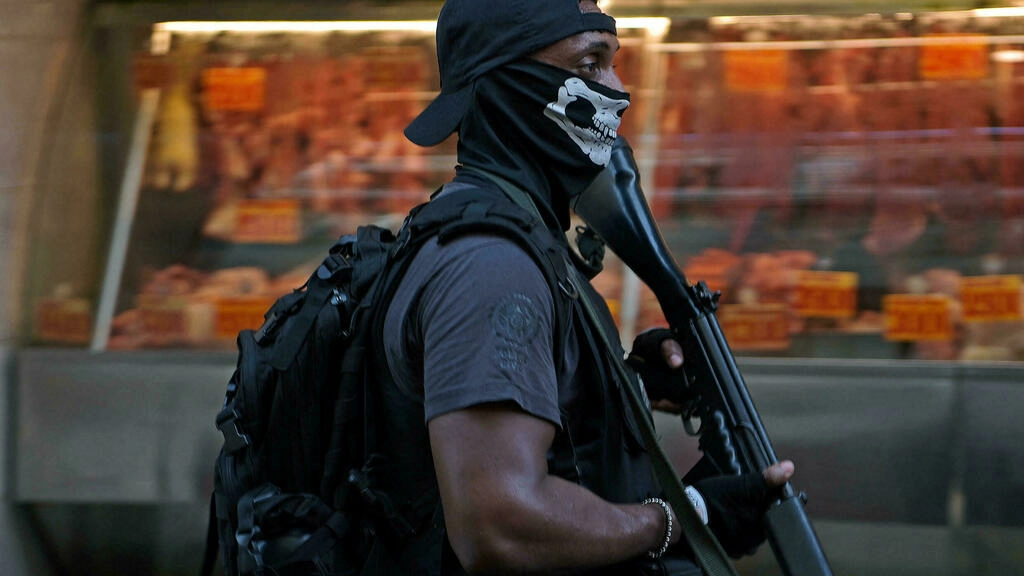 Policial no Jacarezinho com touca ninja e fuzil na mão. Foto por Carl de Souza AFP