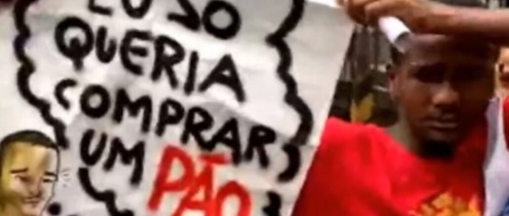 Yago Corrêa ao sair do presídio, depois de ganhar liberdade provisória, segurando uma faixa onde está escrito "Eu só queria comprar um pão".
