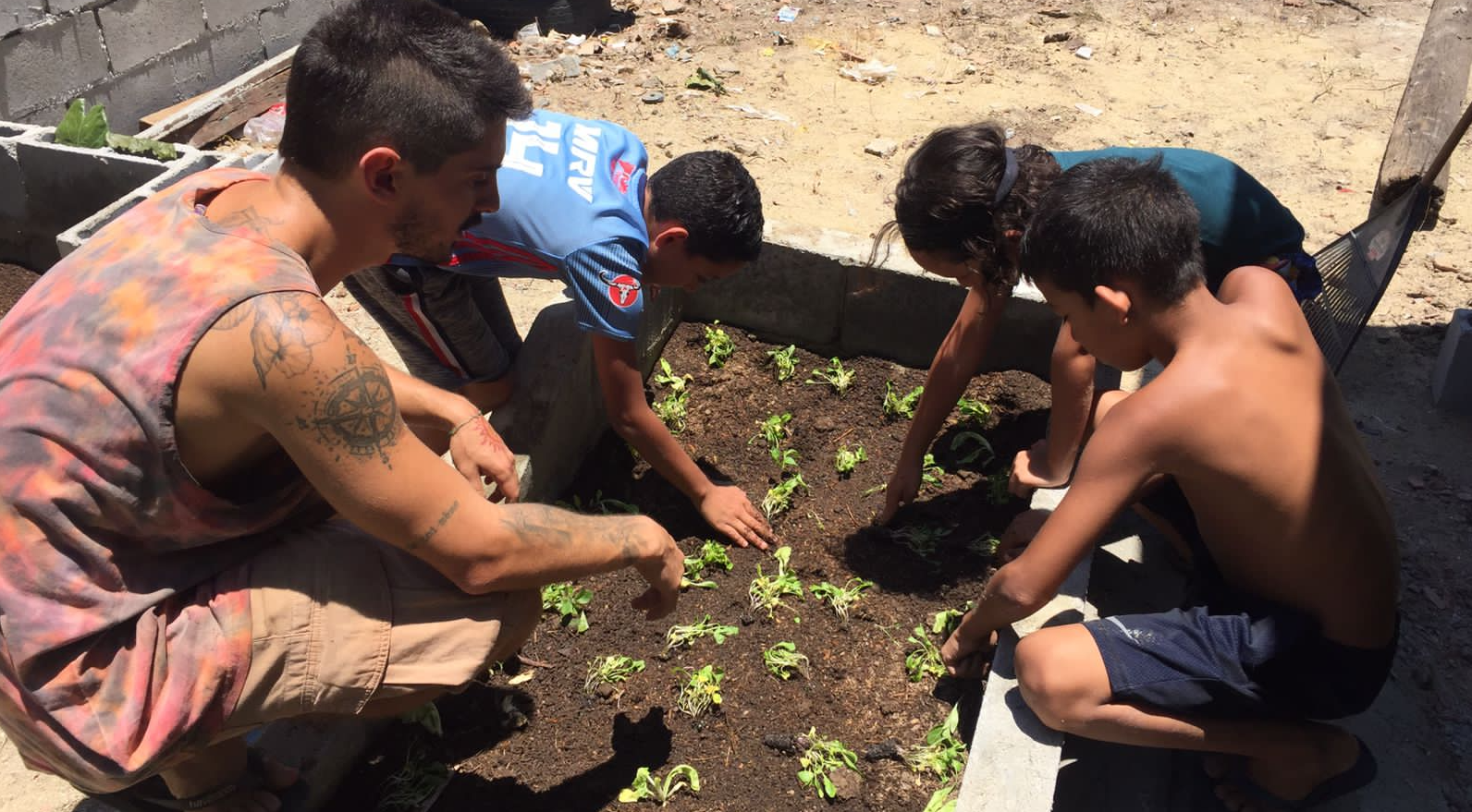 Crianças plantando mudas na Horta-Escola Comunitária Maria Angu. Foto Maria Helena Pereira da Silva, Nena (@nenapereiradasilva)