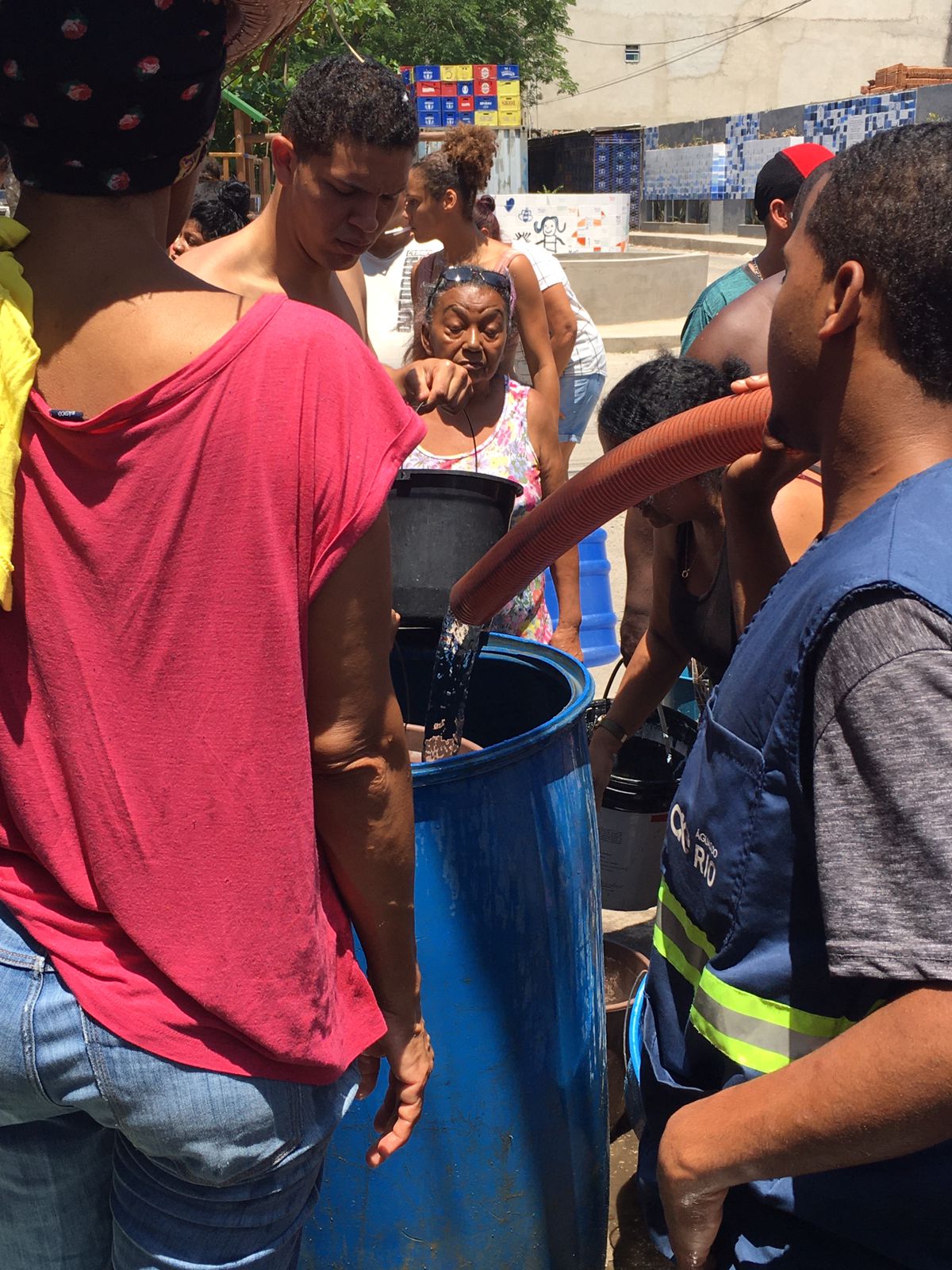 Moradores pegando água no meio da rua em baldes, latas e tinas. Foto: Carlos Viana