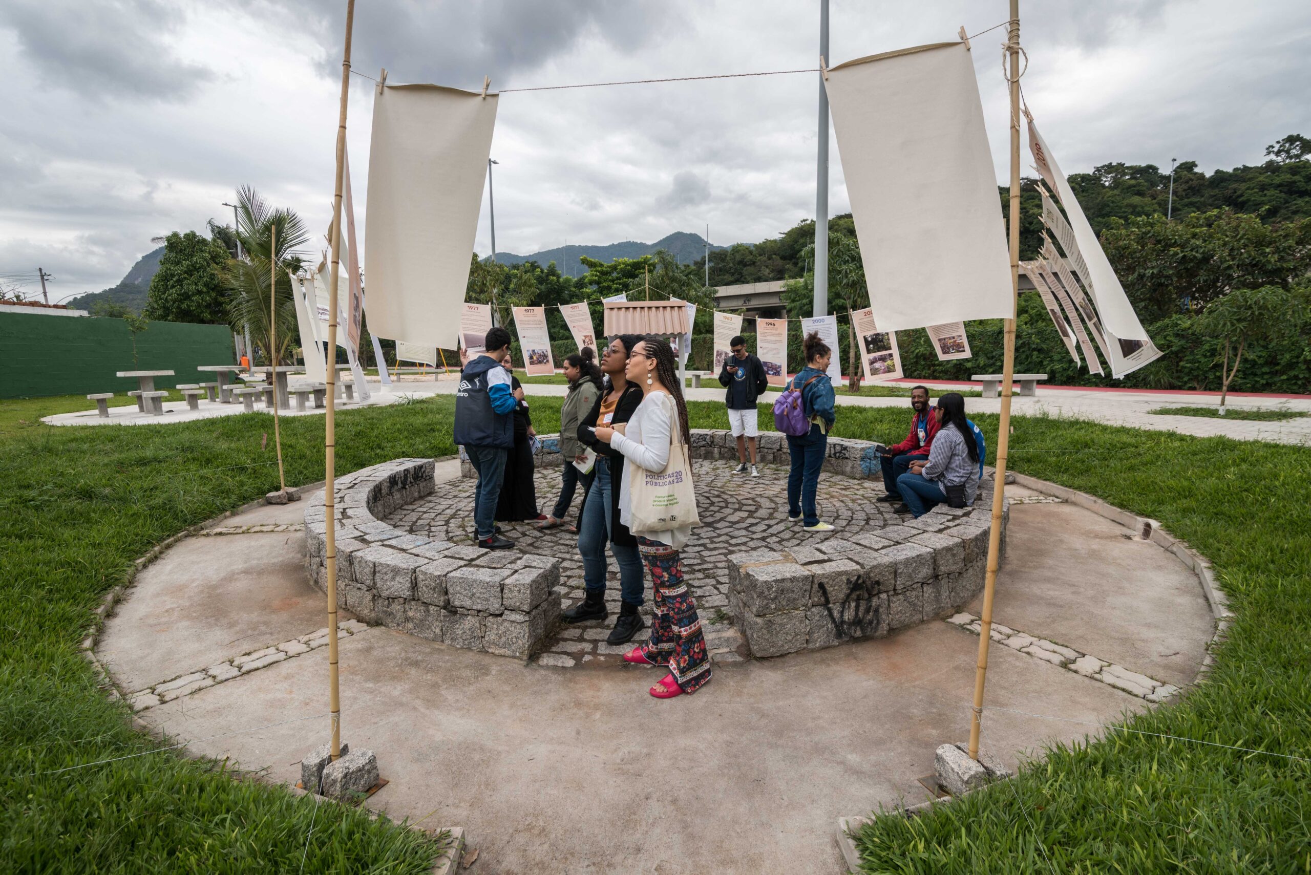 Visitantes observam a linha do tempo que contém uma construção cronológica das memórias climáticas das favelas. Foto: Bárbara Dias