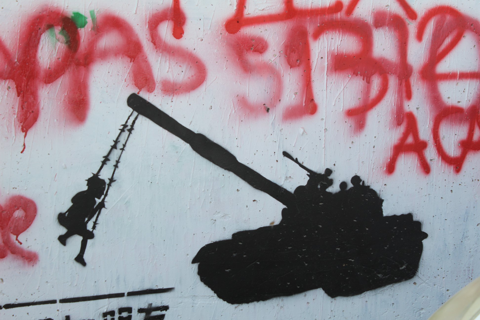 Grafite em Belém, na Palestina, no Muro de Separação, representa o cotidiano da militarização da vida com menina brincando com um blindado como se fosse um balanço. Foto: Julio Santos Filho/EAPPI