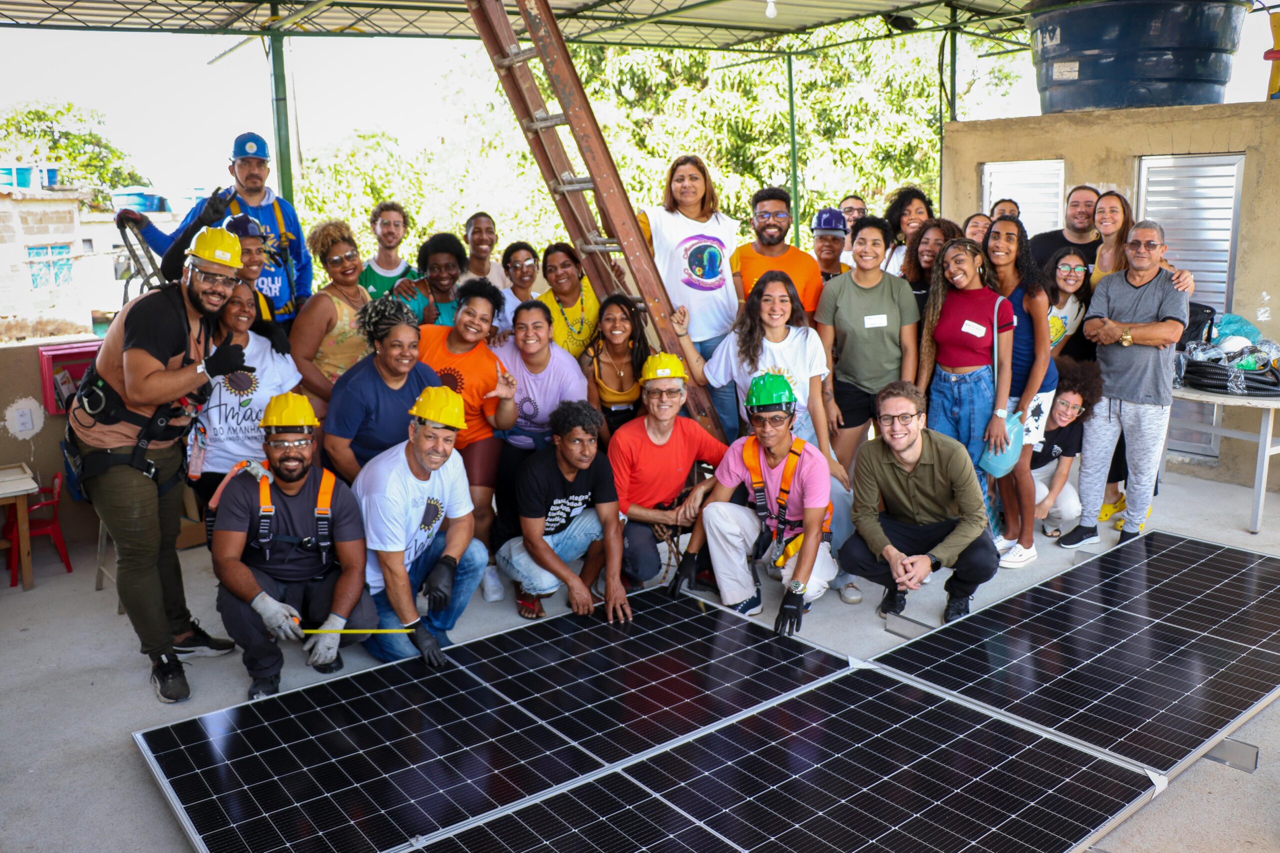Participantes do Minicurso para Embaixadores de Energia Solar da Rede Favela Sustentável (RFS) se reúnem ao redor das placas a serem instaladas. Foto: Alexandre Cerqueira/ComCat
