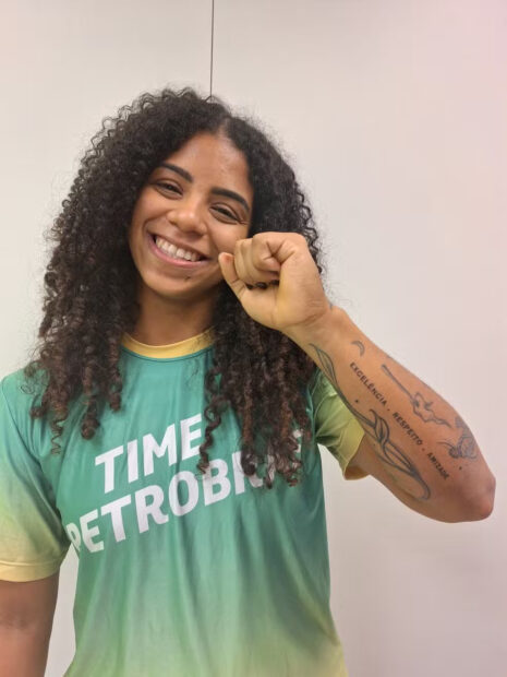 Laura Amaro, atleta do levantamento de peso, cria e Cascadura mostra sua tatuagem, onde se lê excelência, respeito, amizade. Foto: Larissa Carvalho/ge.globo