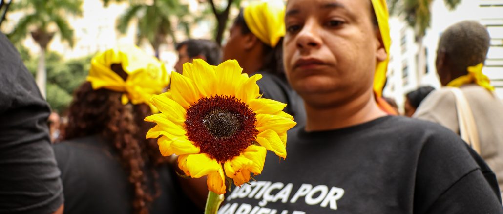 Manifestante segura seu girassol símbolo de memória e resistência em homenagem a Marielle Franco. Foto: Alexandre Cerqueira/ComCat