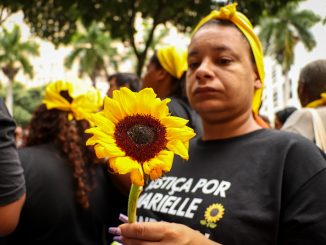 Manifestante segura seu girassol símbolo de memória e resistência em homenagem a Marielle Franco. Foto: Alexandre Cerqueira/ComCat
