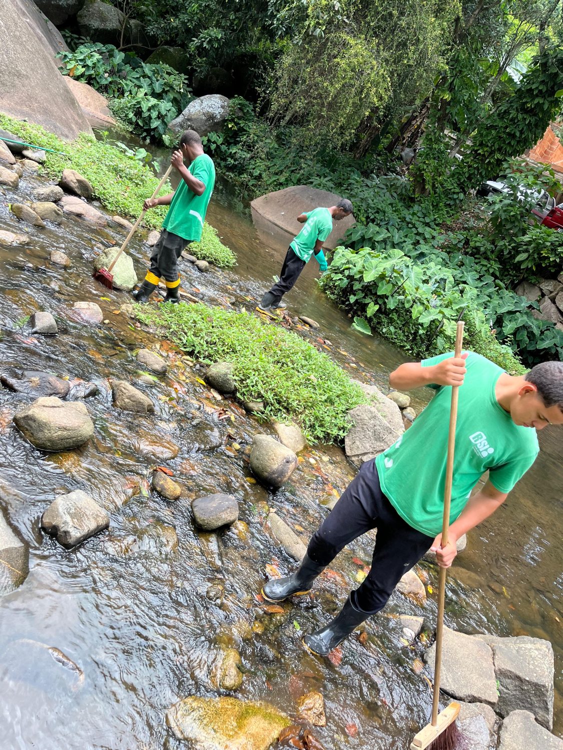 Moradores escovam as pedras para remover ovos de mosquitos, os quais utilizam esses espaços para proliferação. Foto: Rede de Suporte e Integração