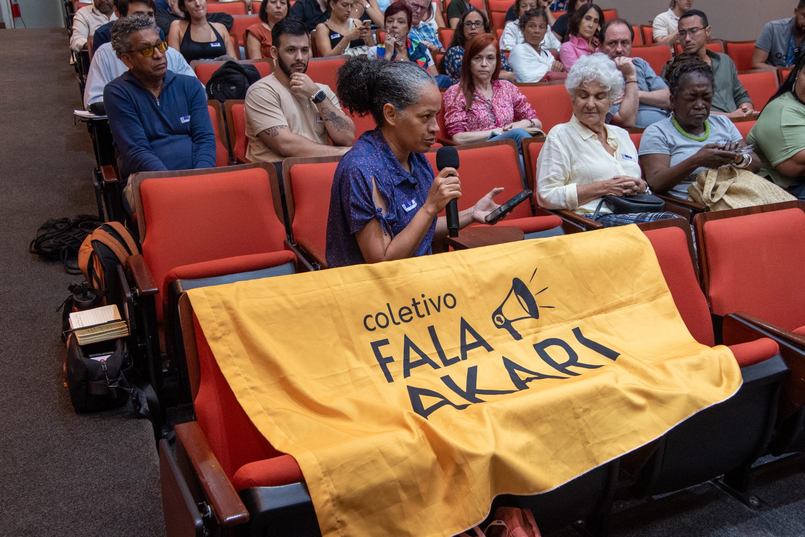 Moradora de Acari e representante do coletivo Fala Akari, indaga perguntas à mesa de palestrantes. Foto: Bárbara Dias Moradora de Acari e representante do coletivo Fala Akari, indaga perguntas à mesa de palestrantes. Foto: Bárbara Dias