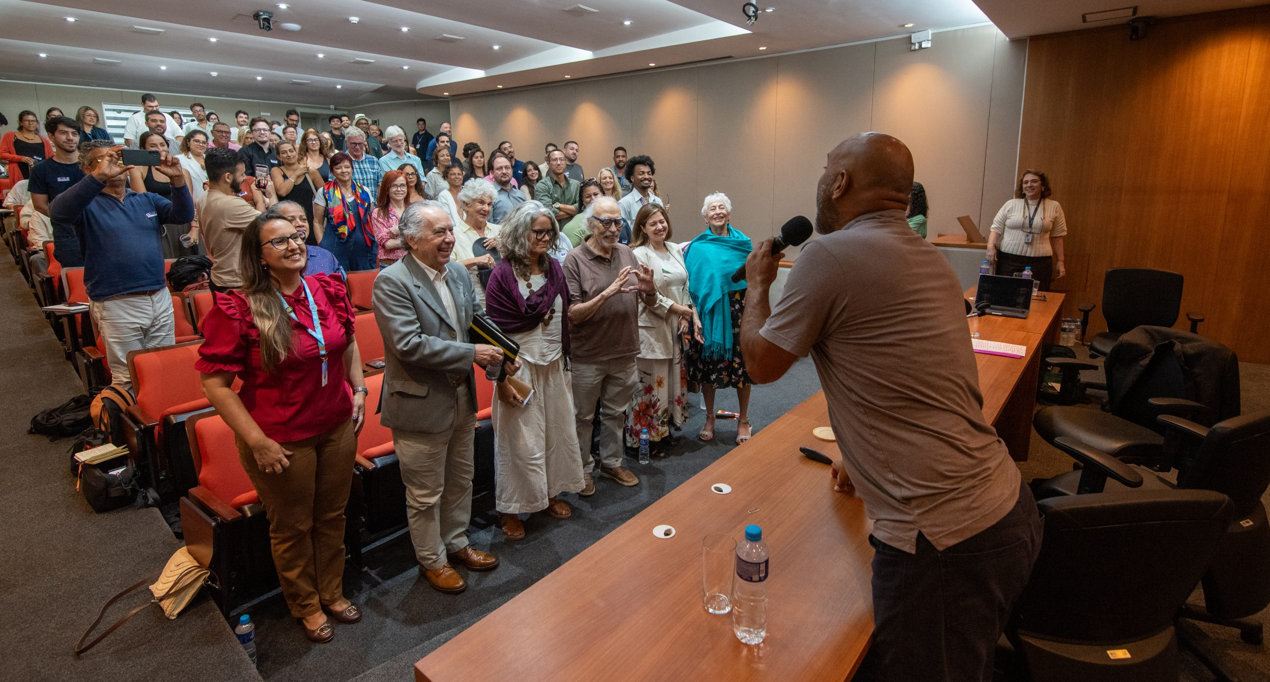 Público presente do auditório participa de dinâmica proposta por palestrante que entoam 'Eu acredito no Rio!'. Foto: Bárbara Dias Público presente do auditório participa de dinâmica proposta por palestrante que entoam 'Eu acredito no Rio!'. Foto: Bárbara Dias