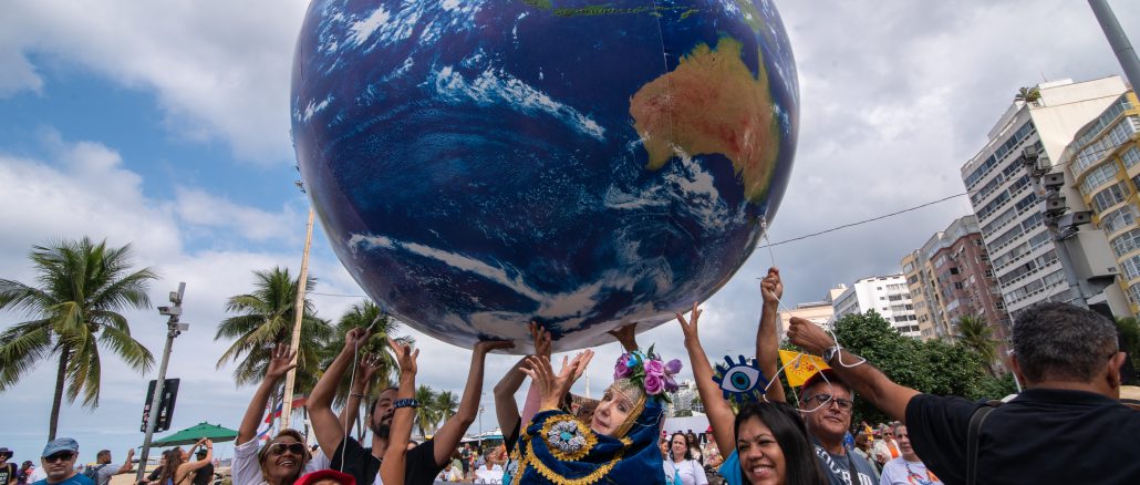 Participantes do Ato Público Ambiental em Copacabana seguram uma réplica inflável do planeta Terra durante caminhada na Avenida Atlântica. Foto: Bárbara Dias